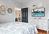 The primary bedroom features queen bedding, a spacious dresser for storing your personal belongings, and a television for winding down at night.