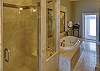 The LUX bathroom features a granite walk-in shower, jetted tub & 2 individual vanities. The photo shows the huge walk-in closet to right.