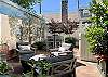 The outdoor oasis is lush with comfy seating for dining or drinks. Features a European-inspired wall mural.