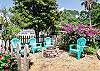 The picket fence gate opens up to our fire pit & seating area under the magnolia tree!