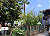 Street view of the entrance to home through the picket fence gate.