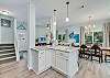 Gorgeous coastal cabinetry and marble tops flow into the dining and living areas