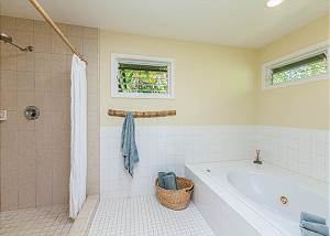 Jetted tub, dual shower heads in the tiled master bathroom. 