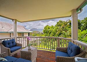 Covered lanai with lush surroundings.