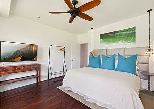 Guest Bedroom with large tv, ceiling fans, and nice decor