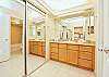 Bright bathroom with a large double-sink vanity, granite counters, and mirrored closets for ample storage.