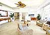 Bright, airy lobby seating area with wicker chairs, tropical décor, and floor-to-ceiling windows bringing in natural light.