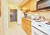 Bright galley-style kitchen with full-size appliances, granite countertops, and all the essentials for home-style cooking.