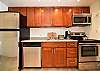 Updated kitchen featuring stainless steel appliances, granite countertops, and custom wood cabinetry.