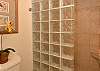 Spacious walk-in shower with glass-block accents and warm tile surrounds.