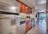 Bright, fully equipped kitchen with stainless steel appliances and a clear view into the open living and dining space.
