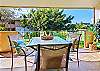 A cozy outdoor dining table surrounded by lush tropical landscaping — perfect for morning coffee or sunset meals.