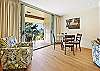 Bright living area with large sliding doors opening to the lanai and greenery.