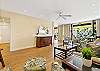 Bright living area with large sliding doors opening to the lanai and greenery.