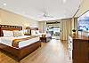 Spacious bedroom with a king bed, soft lighting, and warm wood flooring for a relaxing retreat.