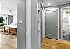 Clean and modern hallway connecting the bedroom and bathroom areas with built-in shelving and updated finishes.
