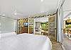 Spacious bedroom featuring French doors, a flat-screen TV, and sliding glass doors that open directly to the lanai.