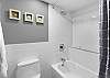 Clean and modern bathroom featuring a sleek shower-and-tub combo with subway tile and contemporary fixtures.