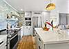 Beautifully updated kitchen featuring stainless steel appliances, open shelving, and a large quartz island perfect for cooking and gathering.