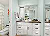 Clean and modern bathroom vanity with ample storage, updated lighting, and fresh coastal finishes.