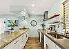Stylish galley kitchen with granite countertops, open shelving, modern fixtures, and premium appliances for effortless meal prep.
