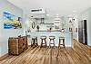 Bright, remodeled kitchen featuring a spacious island with bar seating, modern finishes, and an open layout ideal for gathering.