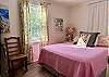 Positioned along the hallway near Queen Bedroom #1, Queen Bedroom #2 shares convenient access to the full bath. Its colorful bedding and curtains enhance the room’s charm, making it a pleasant place to rest.