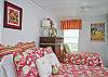 This bright and cheerful bedroom features one twin bed and one queen bed.