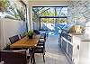 Newly renovated outdoor kitchen with custom marble backsplash and spacious dining table.