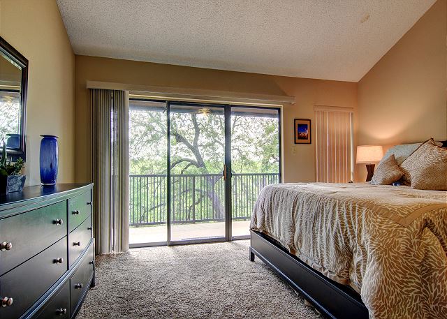 Master bedroom with a King size bed and a balcony.