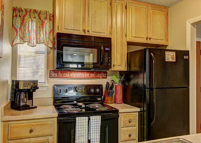 The full size kitchen comes fully equipped with pots, pans, plates, bowls, and utensils. 