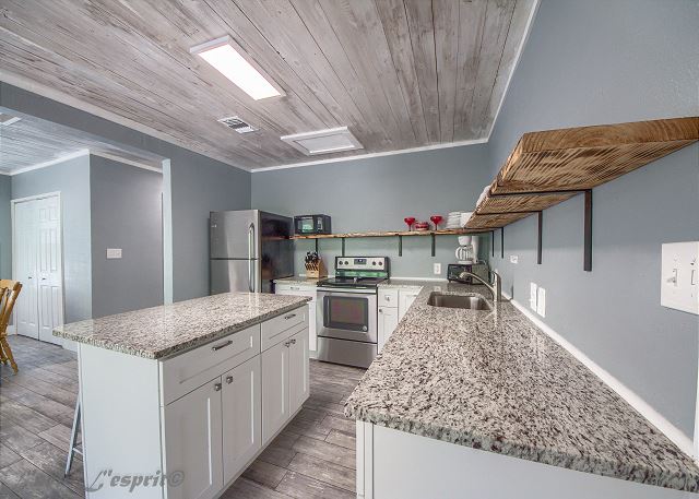 Kitchen with a small island, granite counter tops, and stainless steel appliances. 