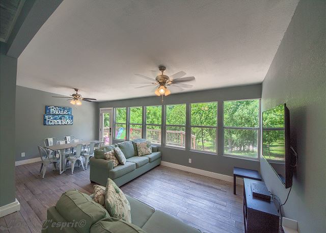 Airy living room is full of light with huge windows looking out onto the new deck and backyard
