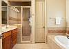 Master bathroom with deep soaking tub, glass shower and private toilet. 