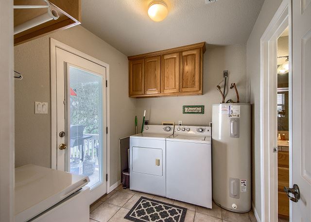 Laundry room is to the right of the kitchen. Has a door that leads to the back patio and the downstairs restroom is the door on the right. 