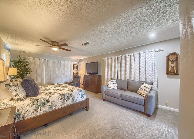 The spacious master bedroom at the end of the hall has a king size bed, a full size sofa sleeper. 