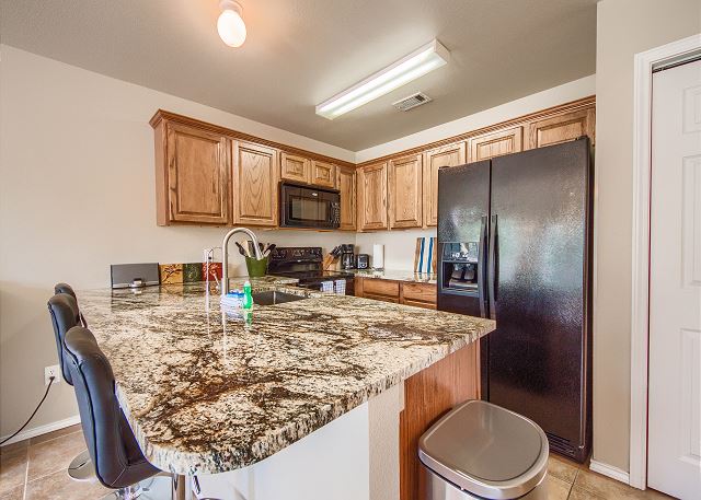 Granite counter tops and a fully stocked kitchen. 