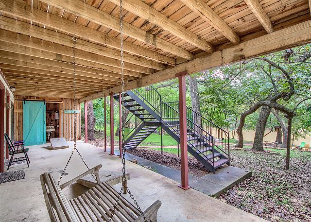 Beautiful covered porch with a porch swing and an outside bathroom!