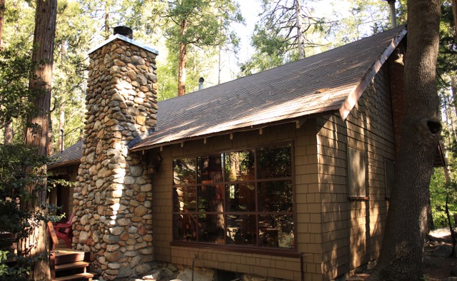 Side view of vintage cabin with rustic stone fireplace.-Original