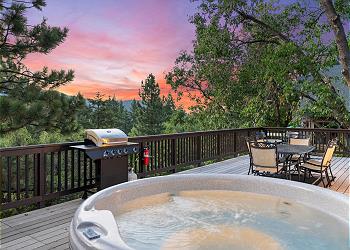 A deck featuring breathtaking mountain views and a relaxing hot 