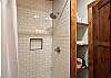 Bathroom with shower, sink and toilet attached to main floor queen bedroom.