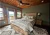 Queen Bedroom upstairs with windows overlooking the lake and private deck.