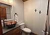 Bathroom with toilet, sink, and shower attached to main floor bedroom.