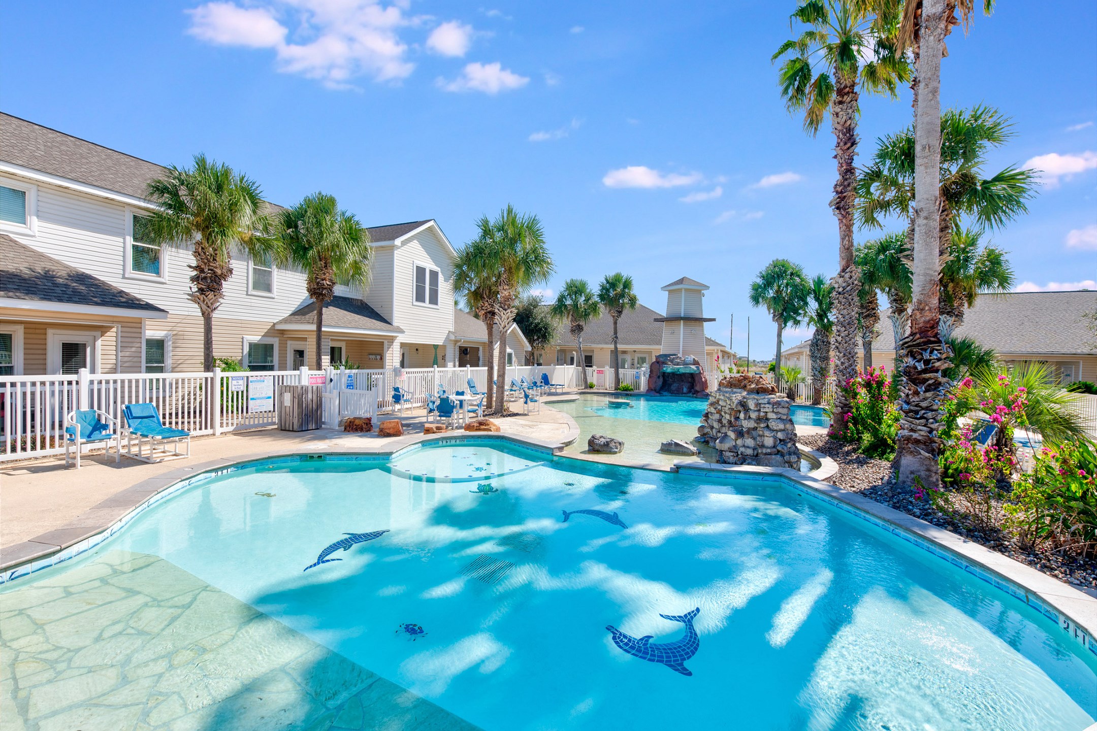 Community pool with beautiful rock features, tropical ambiance and cozy seating throughout