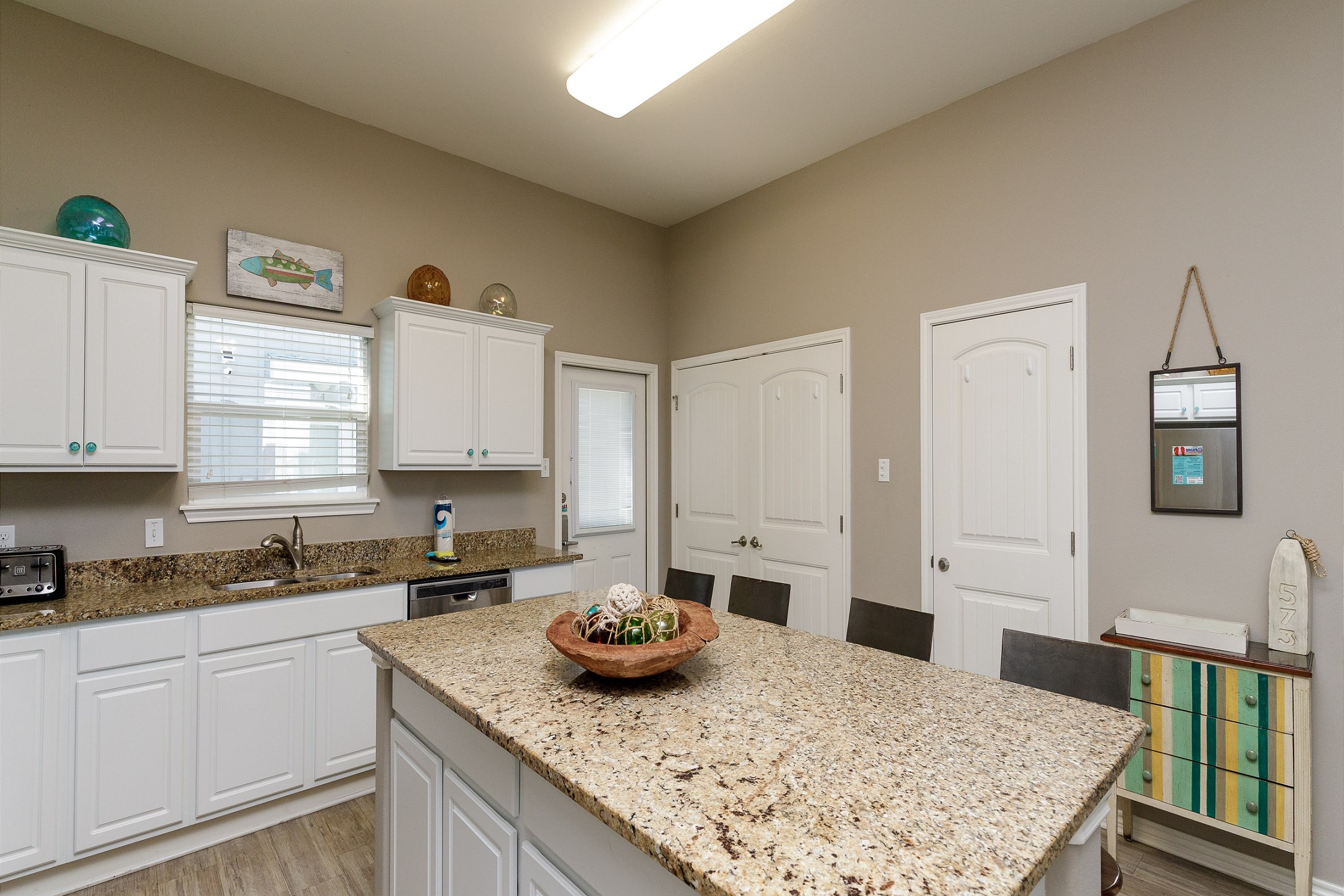 Light-filled modern kitchen with stunning granite countertops and plenty of area for meal preparation