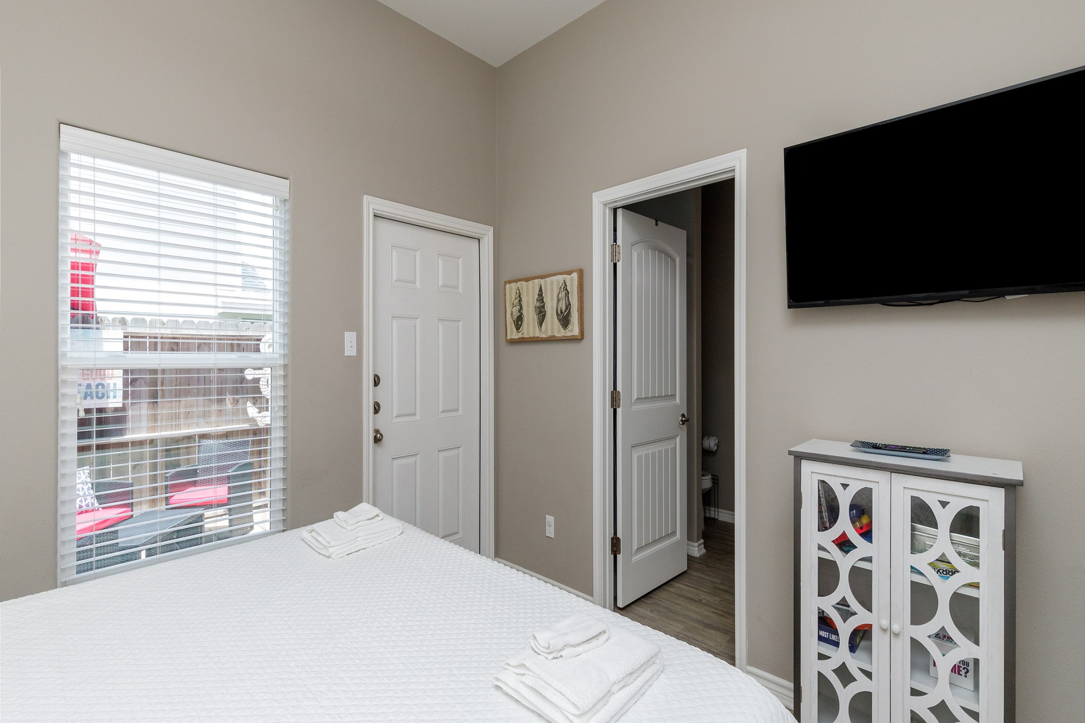 Master bedroom on the first floor with a king size bed, private patio access, ensuite bathroom and flat screen TV
