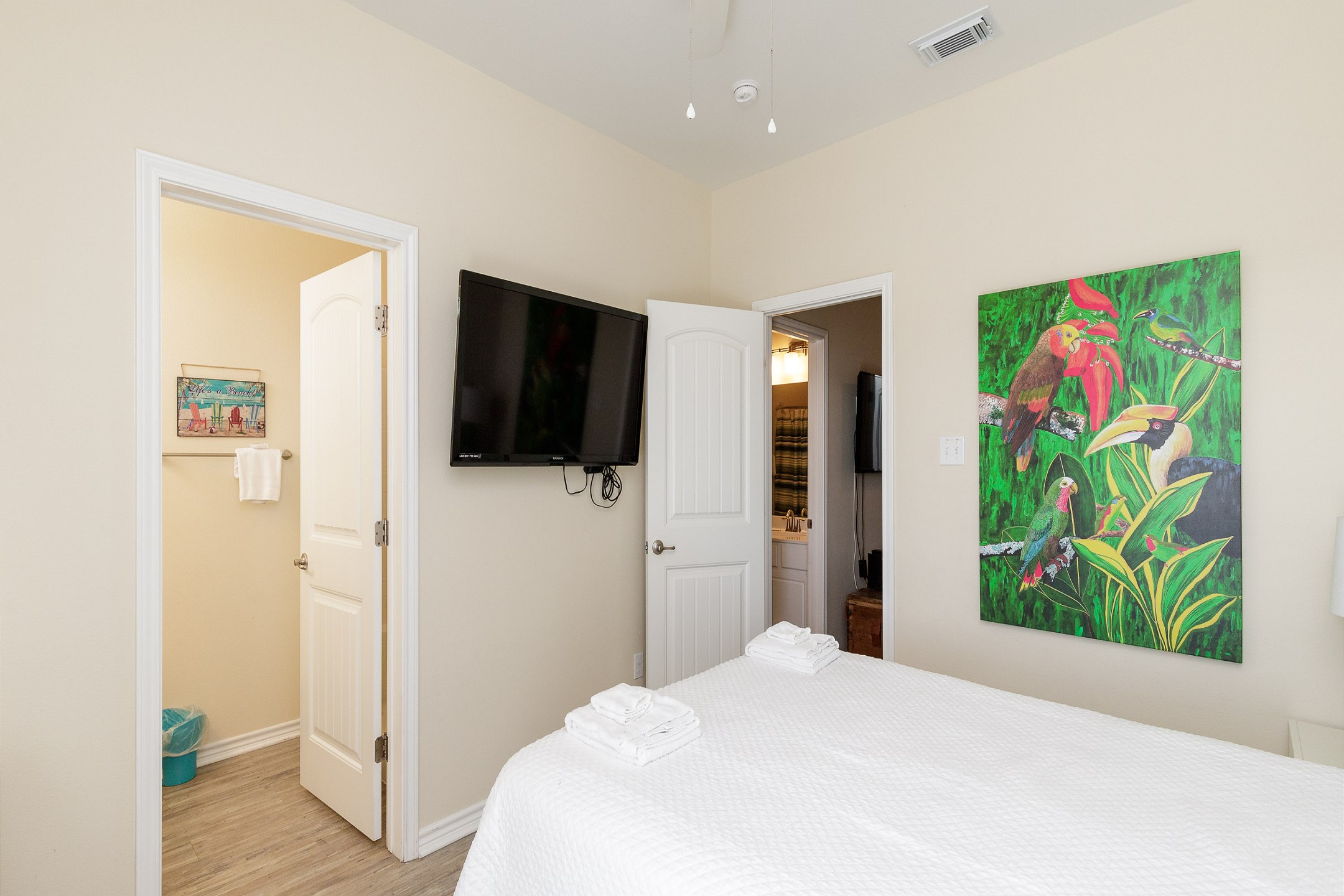 Second floor primary bedroom with a queen size bad, ensuite bathroom, and private patio 