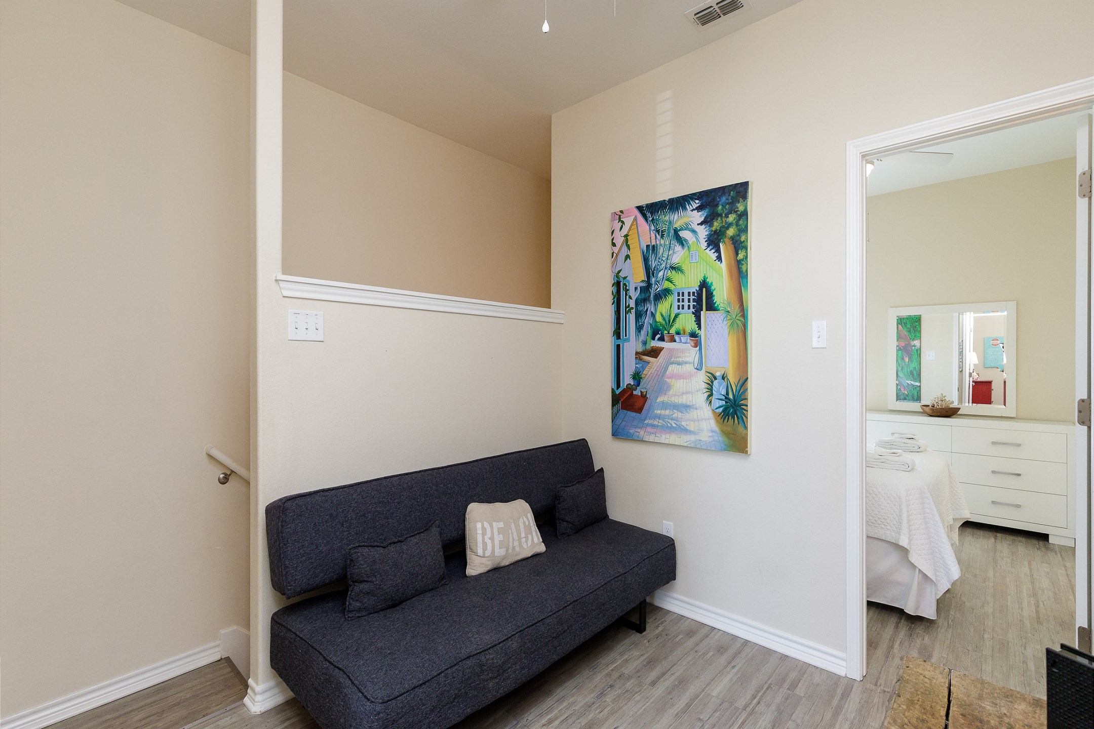 Sitting area on second floor with a one person futon and flat screen TV