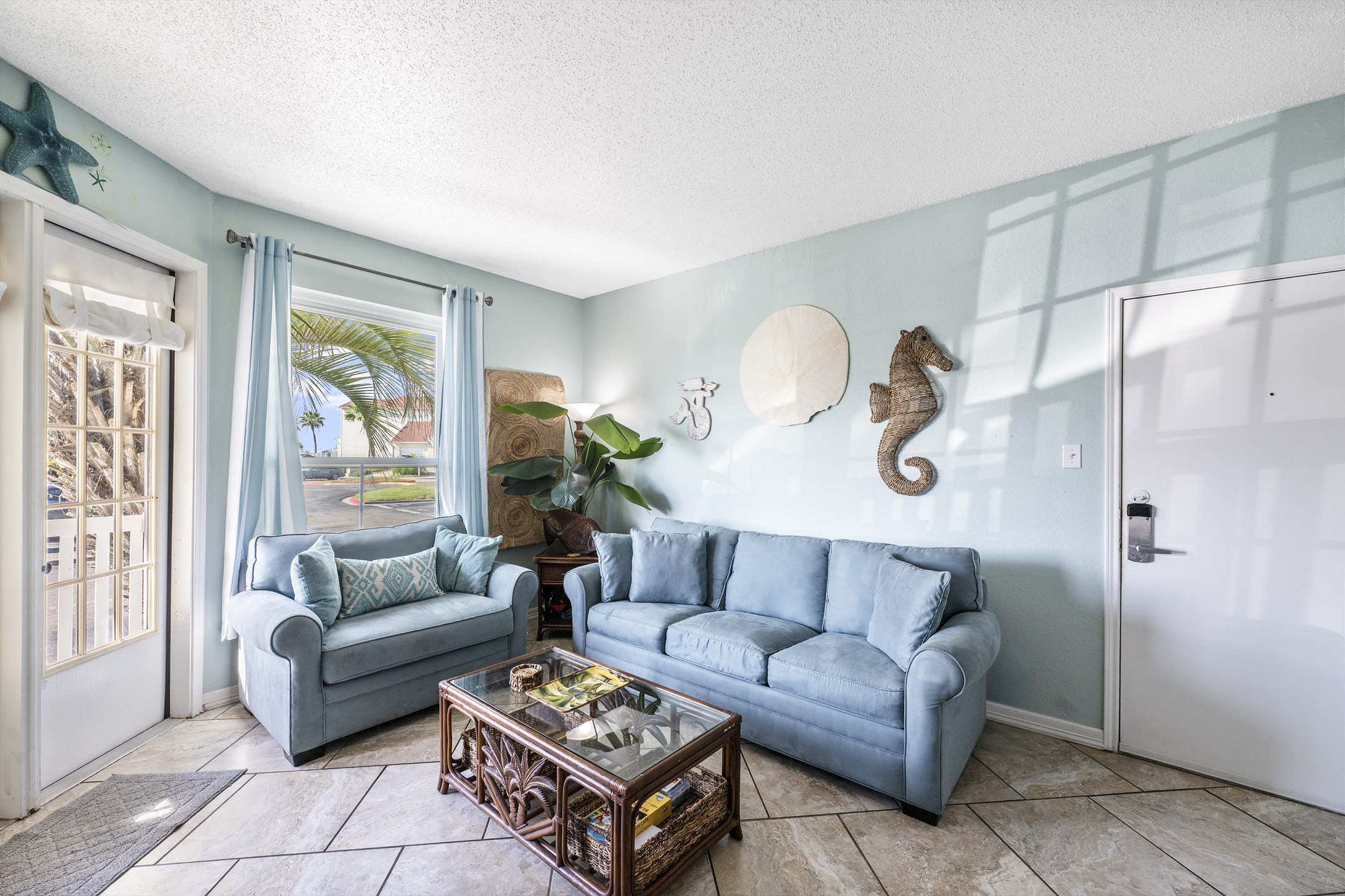 Bright living space with queen size sleeper sofa, coastal views from your window and access to the private patio on the first floor