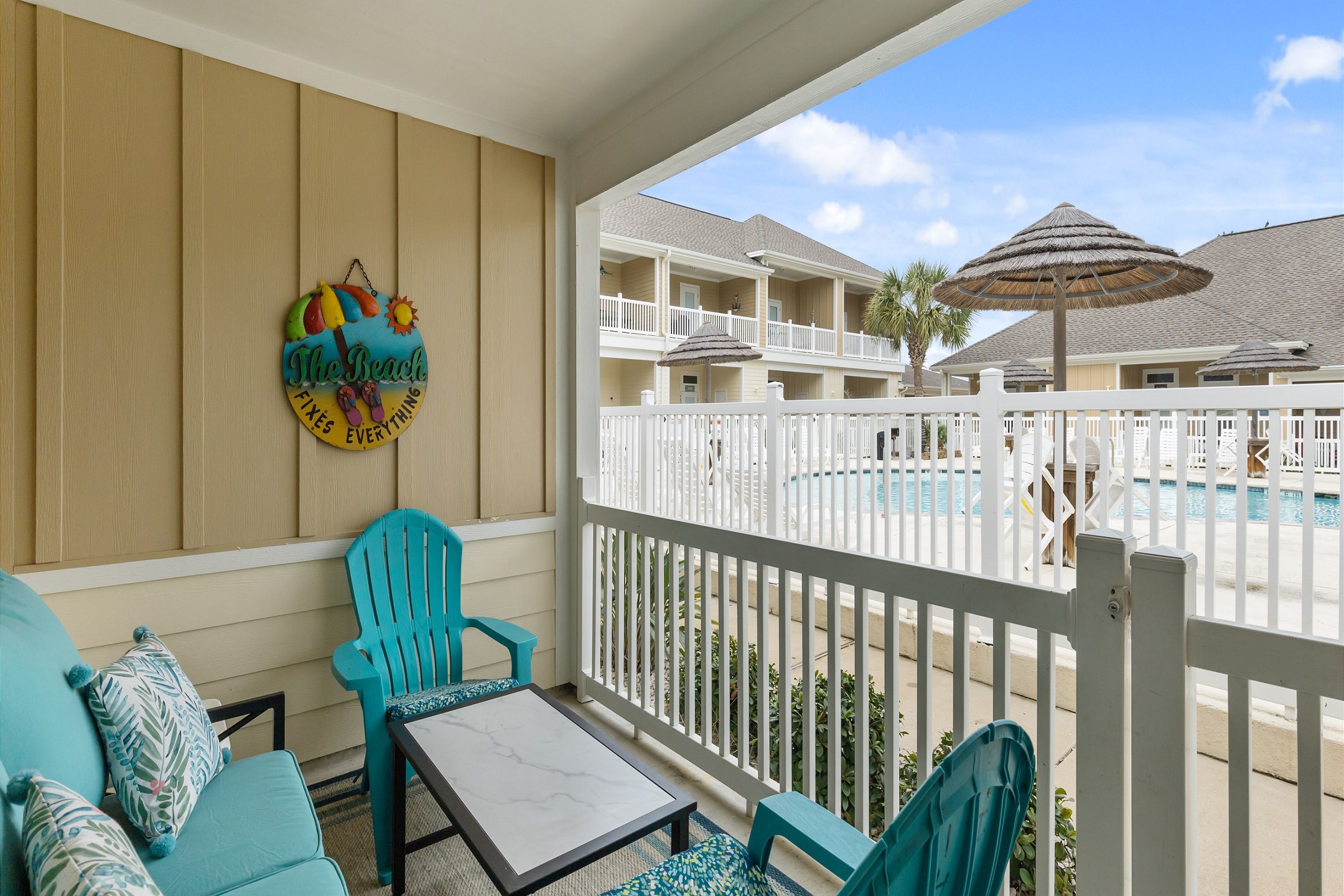 Private patio with new cozy cushions to relax on and a view of the pool 